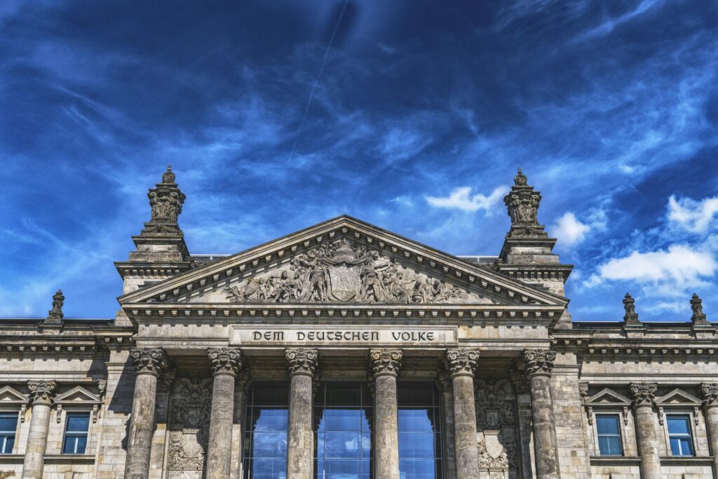 Low angle view of the iconic Reichstag building in Berlin with clear blue skies.